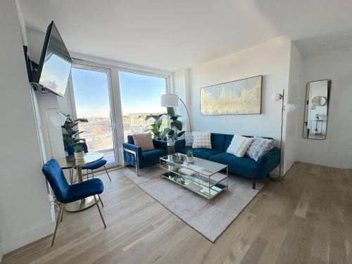 a living room with a blue couch and a table at Modern One Bedroom - Large Private Terrace - Luxury Building - Williamsburg in Brooklyn