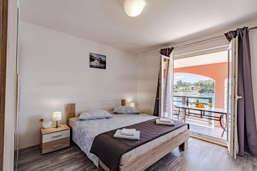 a bedroom with a bed and a balcony at Apartments by the sea Prizba, Korcula - 175 in Prizba
