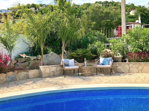 two chairs and a table next to a swimming pool at Villa Marlena, Calonge, Costa Brava,1 luxe private studio-appartement with private pool in quiet area, adults only, Catalonia, Spain in Calonge