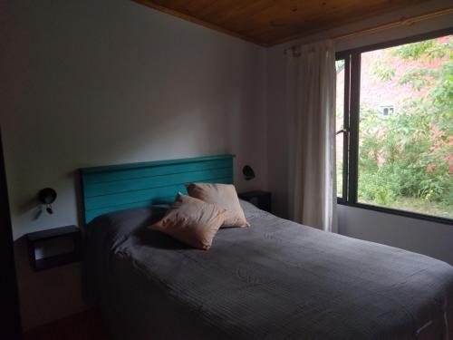 a bedroom with a bed with two pillows and a window at Casa Selva in Costa del Este