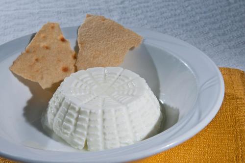 a white plate with crackers and a plate of food at Hotel I Menhirs in Annunziata