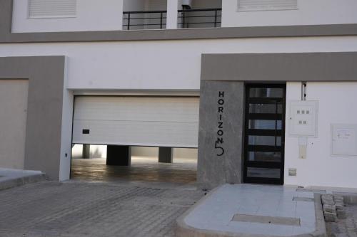 a large white building with a door in the middle at Le soleil jaune in Sfax