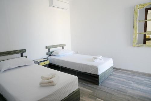 two beds in a room with two towels on them at Le soleil jaune in Sfax
