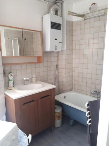 une salle de bain avec un lavabo, une baignoire et un miroir dans l'établissement Batignolles - Parisian appartment, à Paris