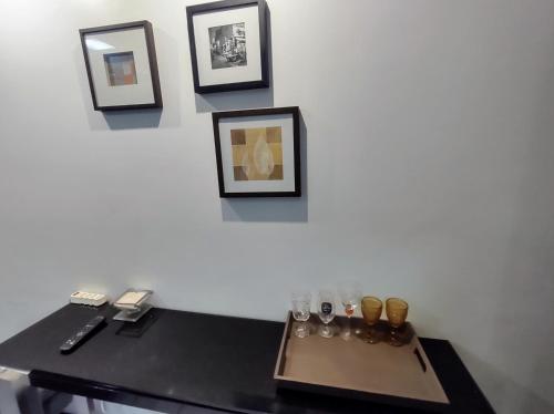 a table with glasses and pictures on a wall at Flat 203 Ed Clarice Lispector, Ilhotas- Rio Poty in Teresina