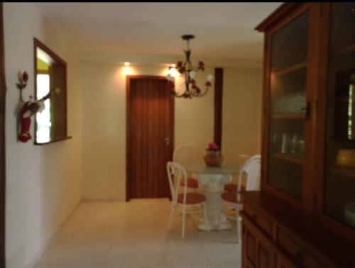 a dining room with a table and chairs and a chandelier at Quinta da Pedra do Elefante in Petrópolis
