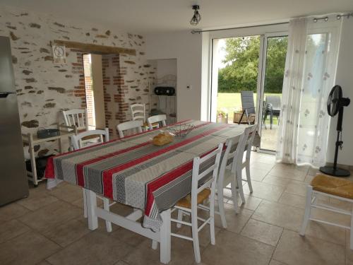 une salle à manger avec une table et des chaises et une fenêtre dans l'établissement Maison rénovée en pleine campagne avec terrain, terrasse et équipements familiaux - FR-1-426-157, à La Roche-sur-Yon