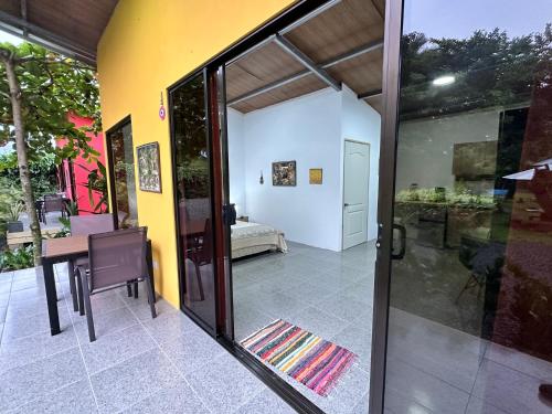 an open door to a room with a table and a bedroom at Uvita Oasis Retreat with Villa Cabins and Apartment in Uvita