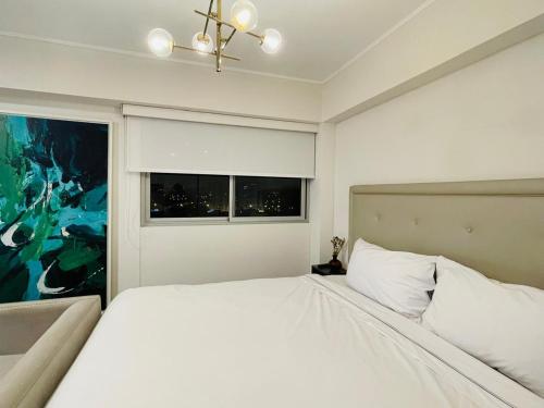 a bedroom with a large white bed and a window at Connect Studios by Vibrant in Lima