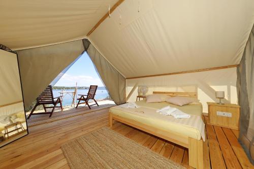 a bedroom with a bed in a tent at Rooms by the sea Cove Golubovac, Kornati - 23062 in Bizikovica