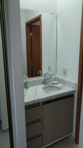 a bathroom with a sink and a mirror at 2 Evangelistas Apartamentos in Cachoeira Paulista