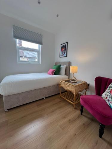 a bedroom with a bed and a couch and a table at 2025 Award Winner Liverpool Cherry House - 4 Bedrooms in Liverpool