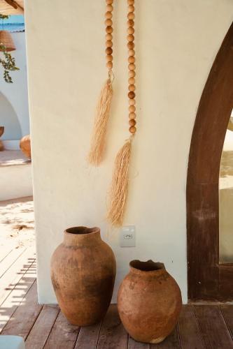 two vases sitting on the floor next to a wall at Anacardier Privé Hotel in Atins