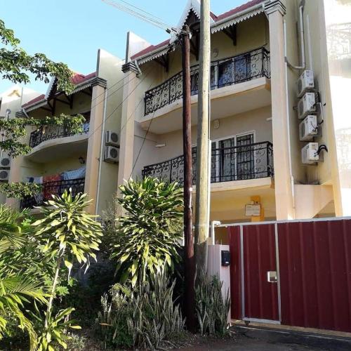 a building with a red gate in front of it at Avenue soleil sur mer flic en flac in Flic-en-Flac