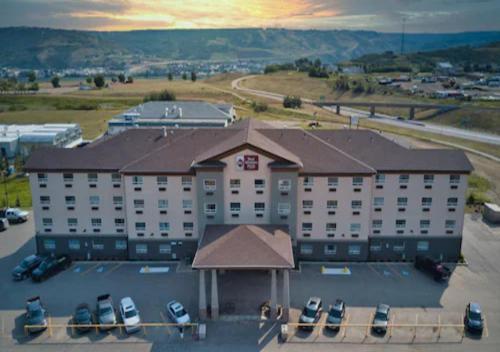 a large hotel with cars parked in a parking lot at Best Western Plus Peace River Hotel & Suites in Peace River