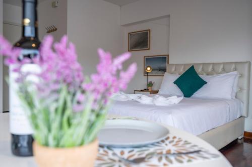リマにあるChateau Studios by Vibrantのベッドと花のテーブルが備わるホテルルームです。