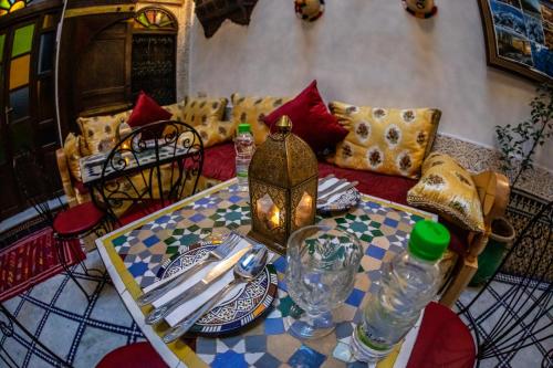 a living room with a table and a couch at Dar Lalamoune in Fès