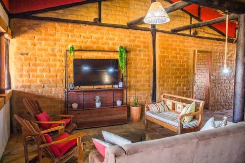 a living room with a couch and a tv at Rancho encontro dos sonhos in Carrancas