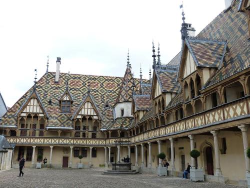 an ornate building with a fountain in a courtyard at voco Beaune , Cité des Vins by IHG in Beaune