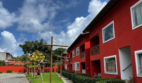 a red building with a basketball hoop in front of it at Condomínio Ecoville das Mangueiras Região de Praia de Guarajuba in Camacari