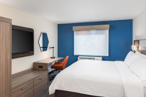 a hotel room with a bed and a desk and a tv at Holiday Inn Express Portland South - Lake Oswego by IHG in Lake Oswego