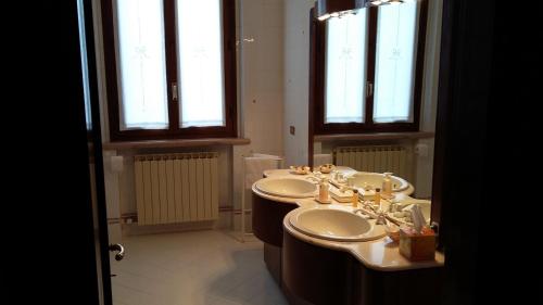 San Giorgio Di MantovaにあるB&B Villafioritaのバスルーム(シンク2台、窓2つ付)