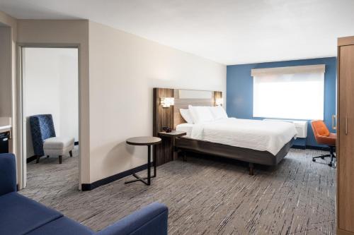 a hotel room with a bed and a table and chairs at Holiday Inn Express Portland South - Lake Oswego by IHG in Lake Oswego