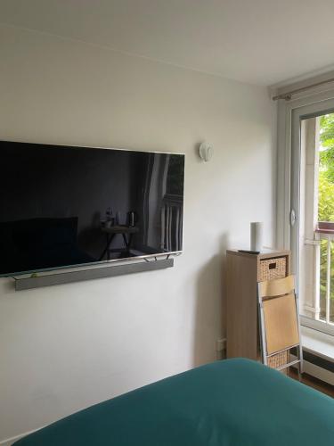 Cette chambre dispose d'un grand miroir mural. dans l'établissement Petit studio tout équipé, à Boulogne-Billancourt