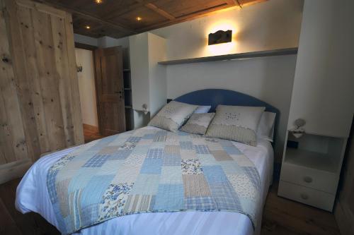 a bedroom with a bed with a blue and white quilt at Historic Residenze Loo Bach in Gressoney-Saint-Jean