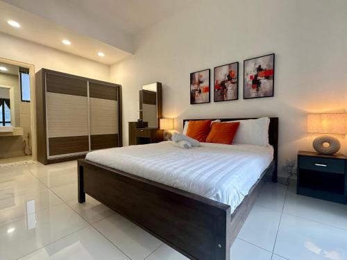 a bedroom with a large bed with orange pillows at Stylish Urban Oasis Icon City with Sky Pool and Cozy Interior in Petaling Jaya