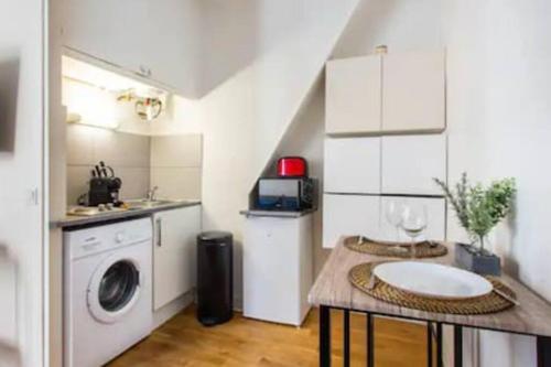 une cuisine avec un évier et une machine à laver dans l'établissement Sevres Cosy studio, à Paris
