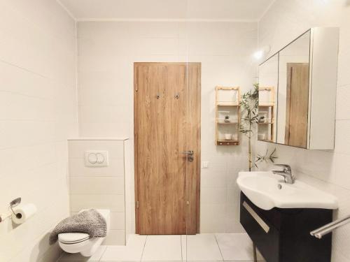 a bathroom with a toilet and a wooden door at Caesar Residence in Budapest