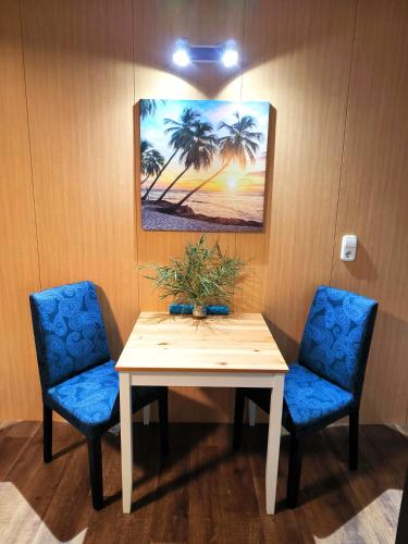 a room with a table and two blue chairs at Caesar Residence in Budapest