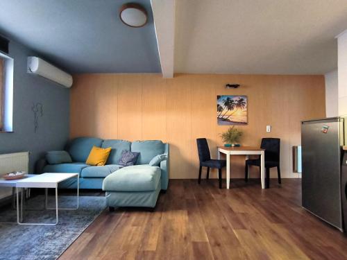 a living room with a blue couch and a table at Caesar Residence in Budapest