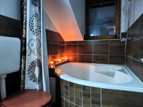 a bath tub in a bathroom with a wooden stool at Caesar Residence in Budapest