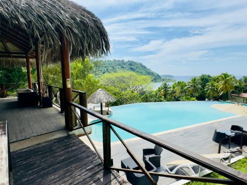 a resort with a pool and a deck with chairs at Ranchos de Chalia Panama in Portobelo