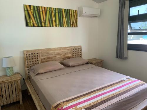 a bed in a bedroom with a picture on the wall at Faré Pépénai in Avatoru