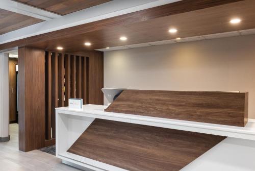 a reception desk in a lobby with wood at Holiday Inn Express Portland South - Lake Oswego by IHG in Lake Oswego