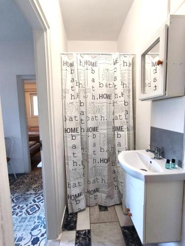 a bathroom with a shower curtain with writing on it at Caesar Residence in Budapest
