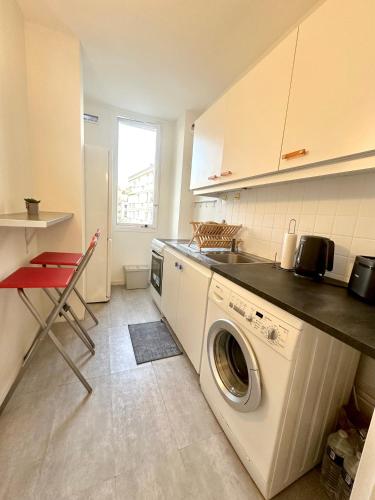 une cuisine avec une machine à laver et un évier dans l'établissement Appart ensoleillé à Boulogne Billancourt, à Boulogne-Billancourt