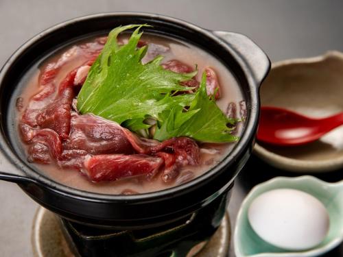 a pot of soup with ailantro leaf on top at Togakubo in Isehara