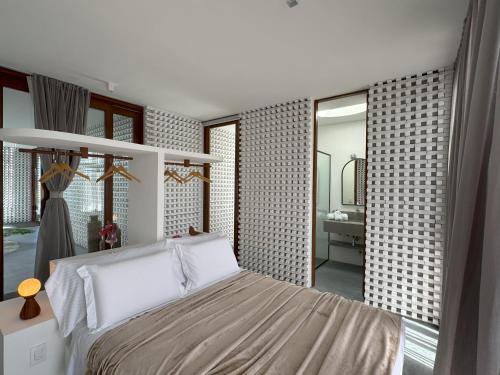a bedroom with a large bed and a bathroom at Pousada Mestizo in São Miguel do Gostoso