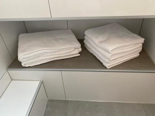 two towels sitting on a shelf in a closet at New York: Messe-/Business-/FeWo Düsseldorf/Hilden in Hilden