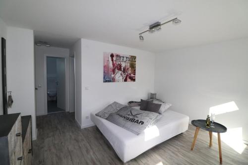 a white living room with a couch and a table at New York: Messe-/Business-/FeWo Düsseldorf/Hilden in Hilden