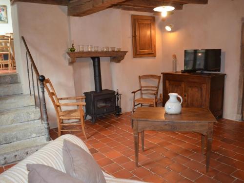 a living room with a wood stove and a table at Gîte de charme avec spa, sauna et jardin pour 12 personnes - FR-1-496-54 in Saint-Just-la-Pendue
