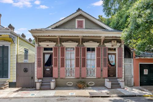 an old house with pink shutters on a street at Royal Barracks Guest House in New Orleans