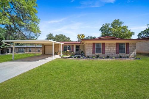 a house with a lawn in front of it at Family and Pet Friendly Stay - 15 Min to Downtown Six Flags SeaWorld very close to hospitals in San Antonio