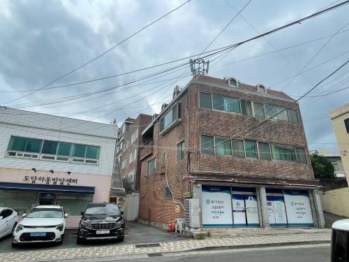 a brick building with cars parked in front of it at sentimental in Busan