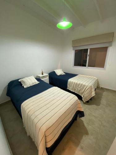 a bedroom with two beds and a window at Casa en Costa Esmeralda in Costa Esmeralda