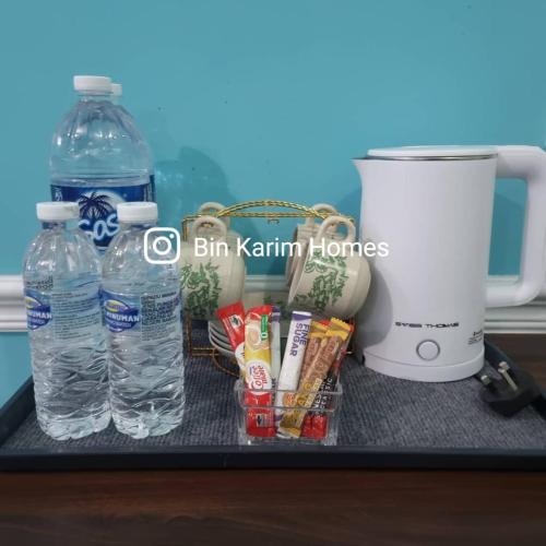 a counter with a blender and bottles of water at The Shore KK by Bin Karim Homes in Kota Kinabalu